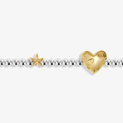 gold heart charm and star on white background