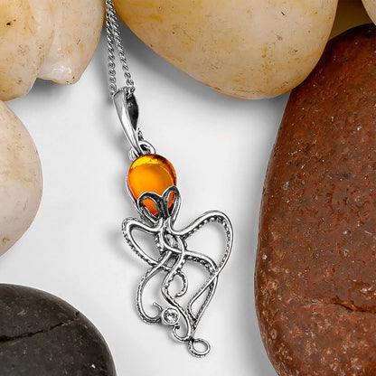 Silver pendant with amber stone on a white background with stones