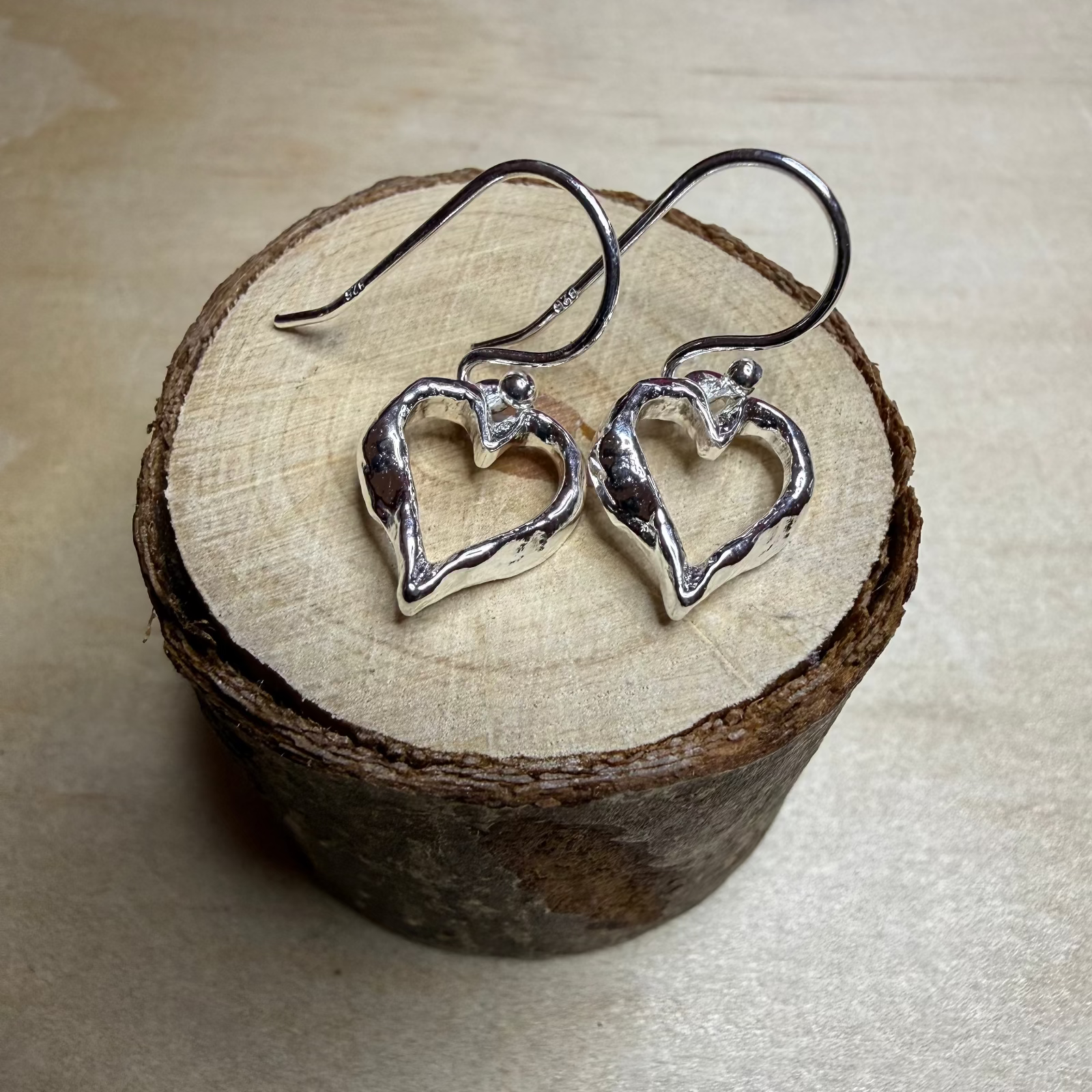 outline-heart-earrings-on-small-wooden-log