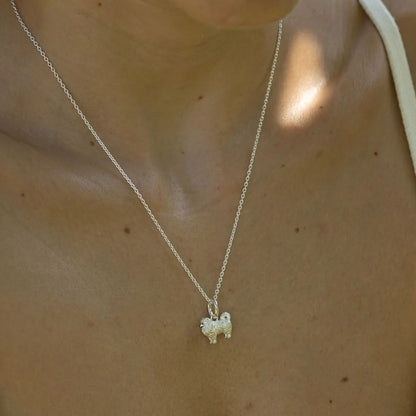 Silver necklace with a dog pendant on a person's neck