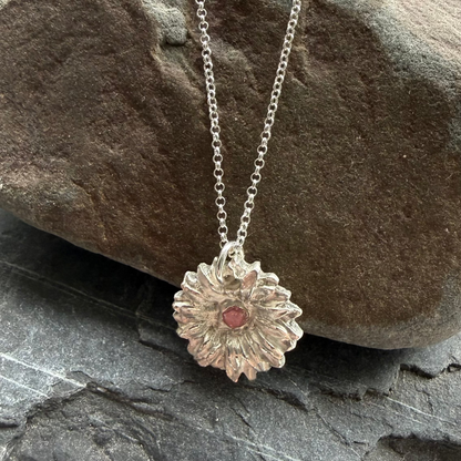 Silver necklace with a pendant on a stack of rocks