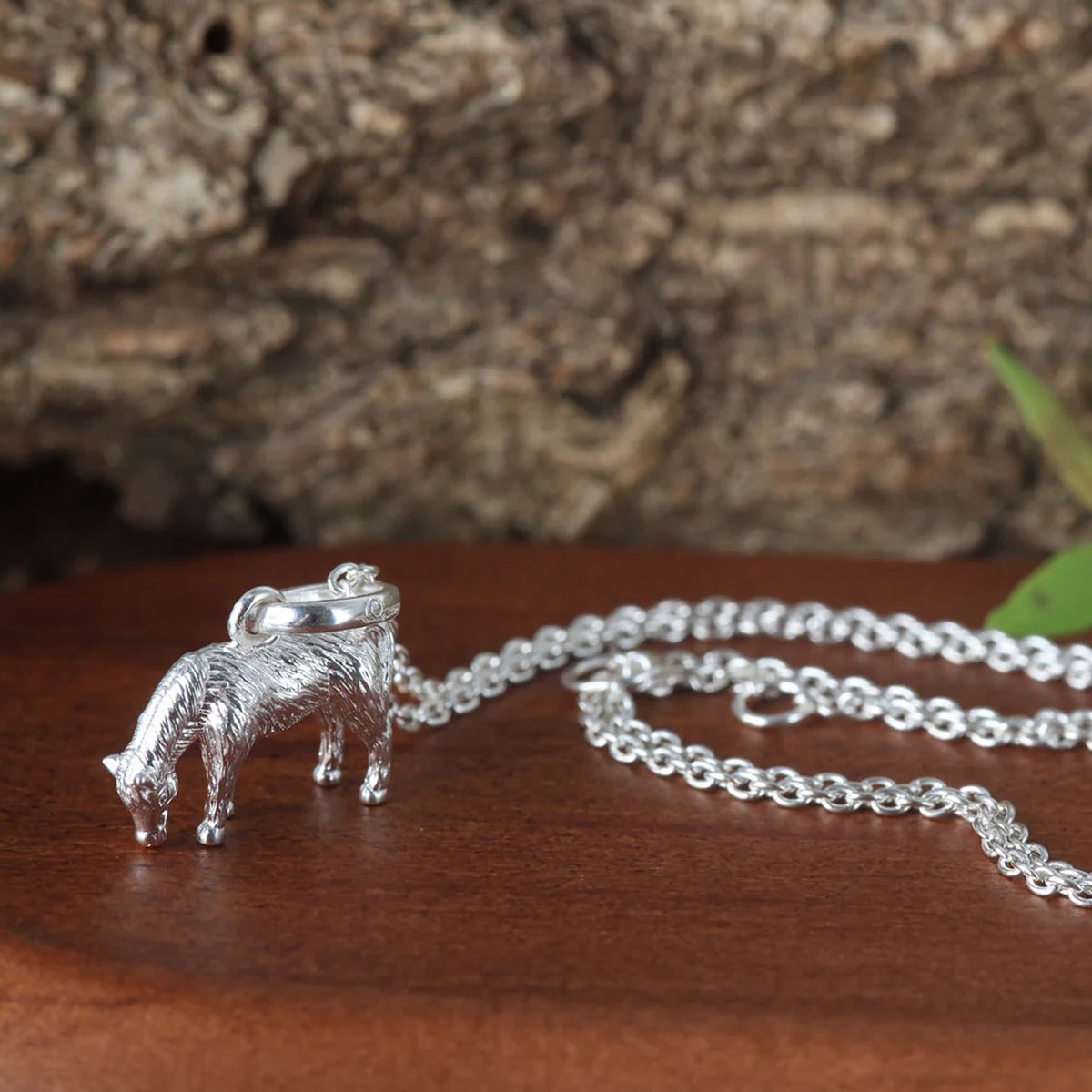 pony silver necklace on brown background