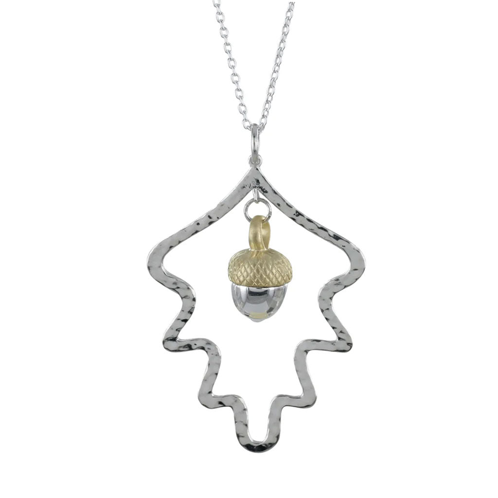 Silver necklace with a textured pendant and gold acorn charm on a white background
