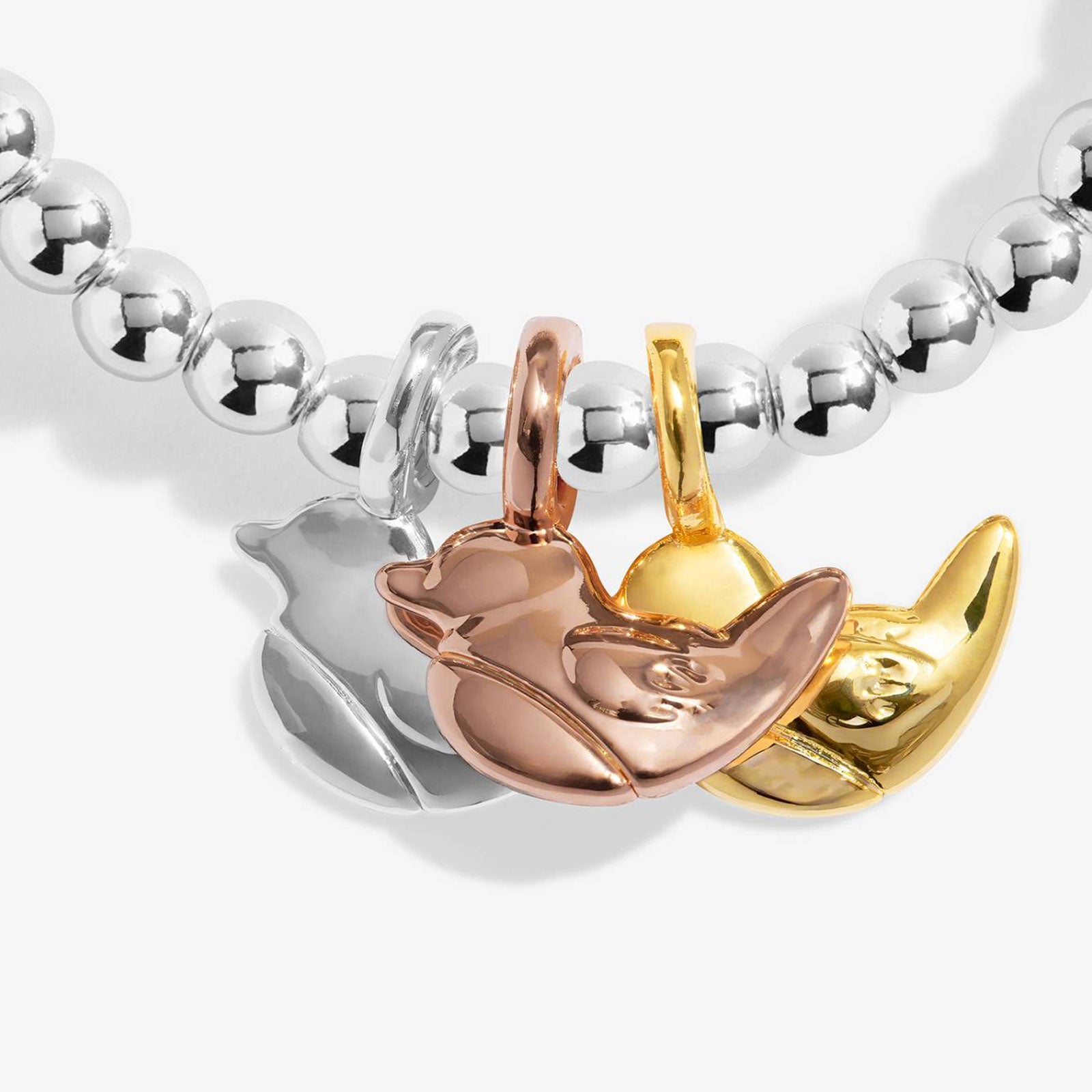 A close-up of a beaded bracelet featuring three metallic animal charms