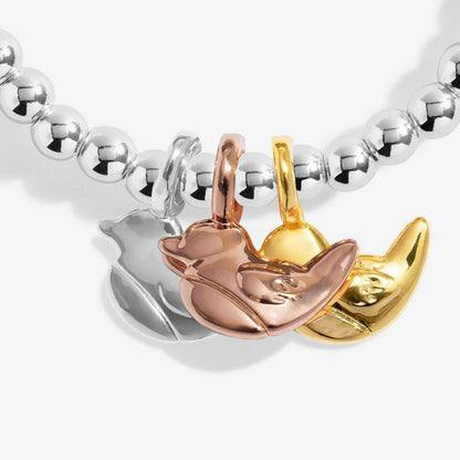A close-up of a beaded bracelet featuring three metallic animal charms