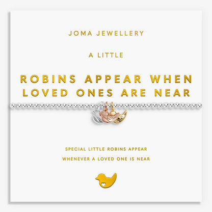 A silver beaded bracelet with a small gold and rose gold robin charm, presented on a white Joma Jewellery gift card with gold text.
