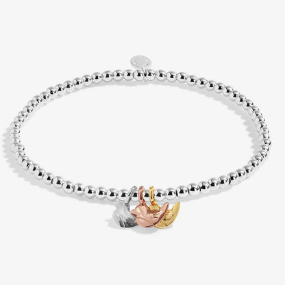 A silver beaded stretch bracelet with a three-tone charm featuring a rose gold flower, a yellow gold crescent moon, and a silver leaf, displayed on a clean white background.