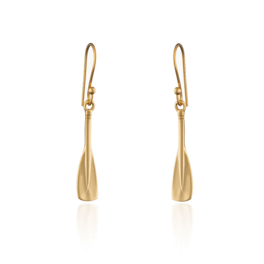 A pair of gold drop earrings shaped like stylized oar blades, suspended from matching gold fishhook wires, shown on a clean white background with a soft reflection below.