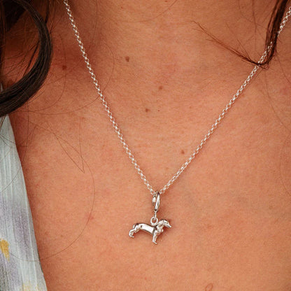 Silver necklace with a dog pendant on a person's neck