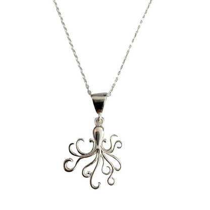 A silver pendant necklace featuring a stylized fleur-de-lis or octopus-like openwork charm on a delicate silver chain, displayed against a light gray textured background.