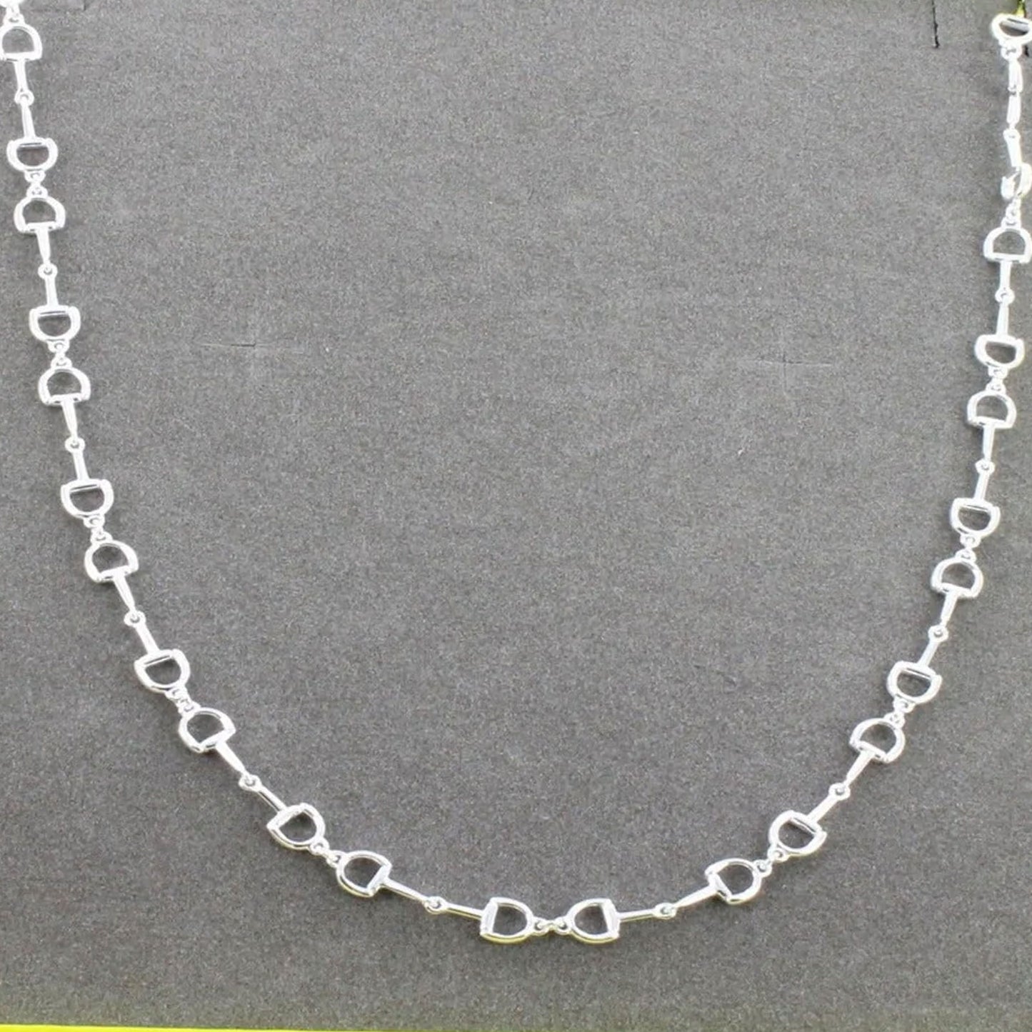 snaffle chain necklace on grey background
