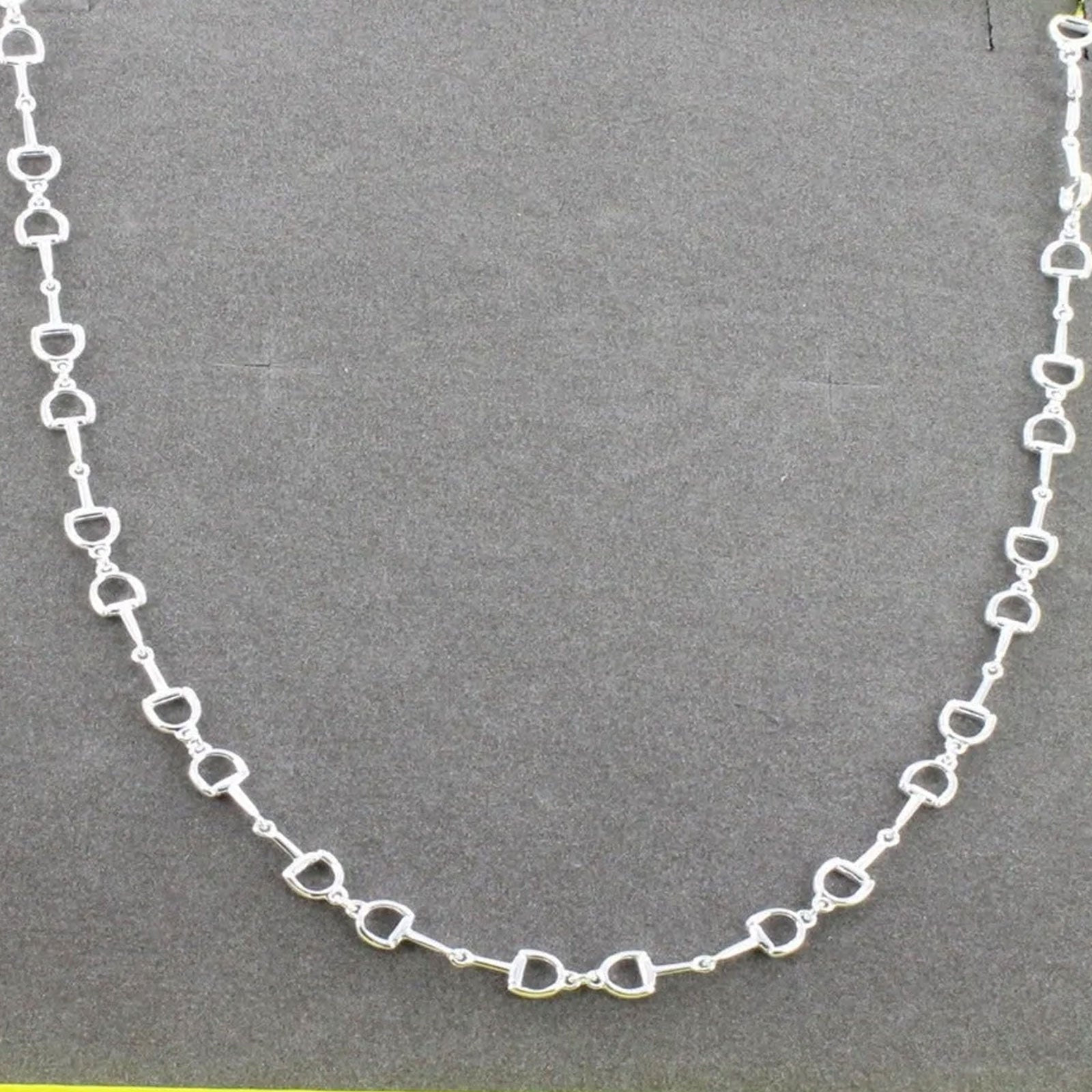 snaffle chain necklace on grey background
