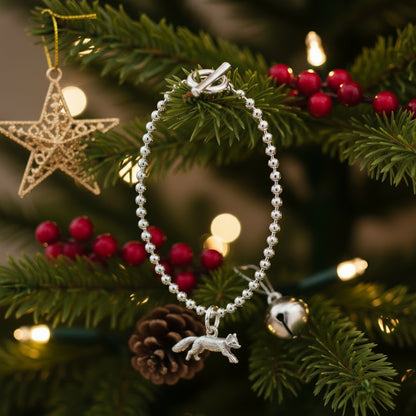 Silver bracelet with a fox charm on a white background