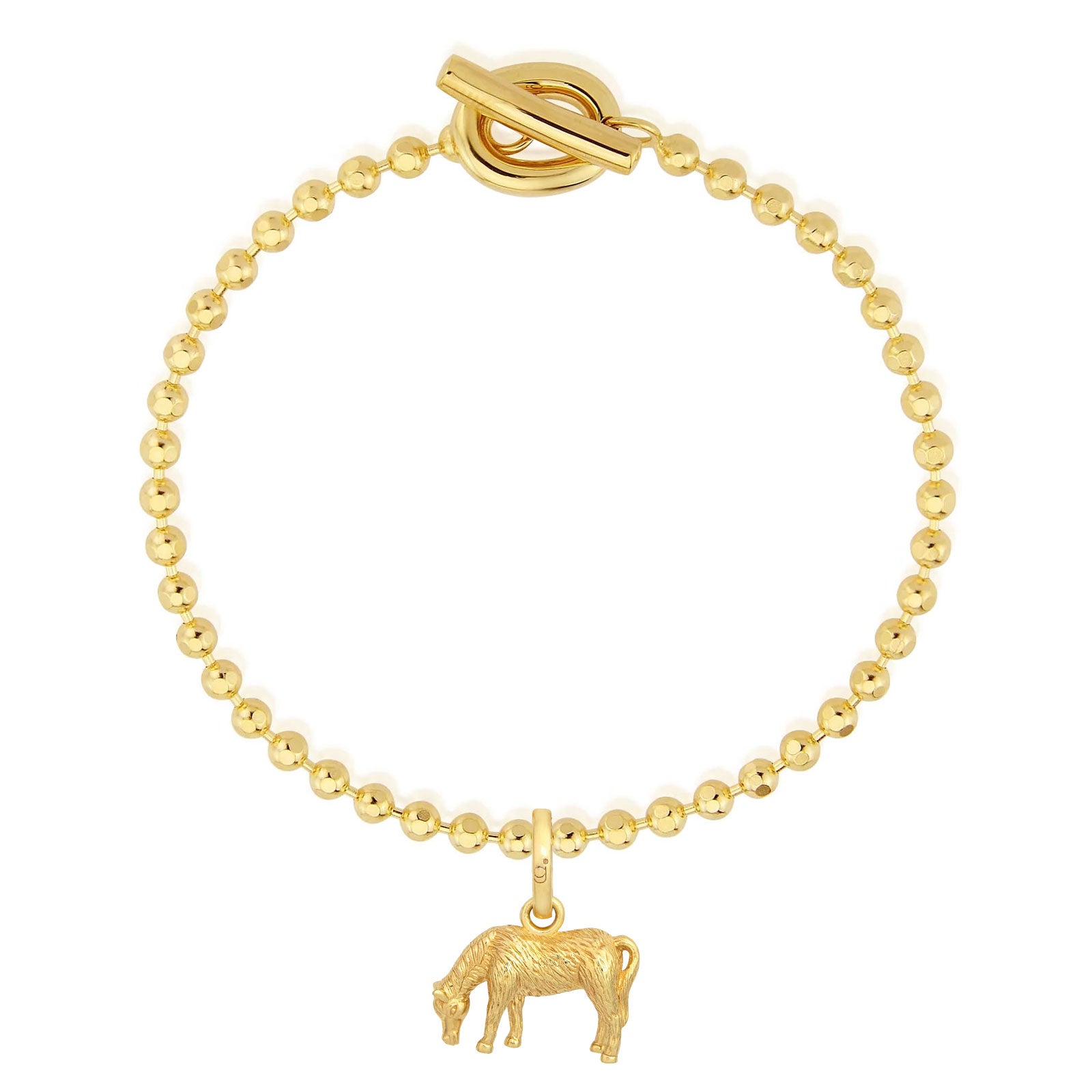 Gold bracelet with a cow charm on a white background