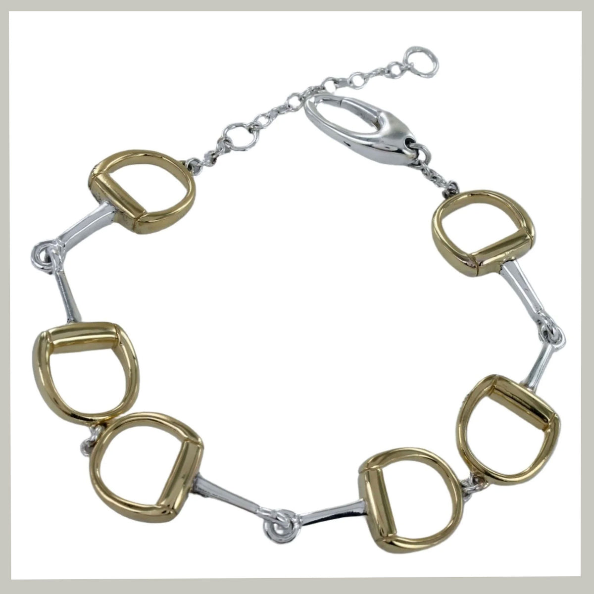 A horse-bit style bracelet featuring alternating gold and silver-toned horsebit links connected by a silver-toned chain with a lobster clasp, shown on a plain white background.