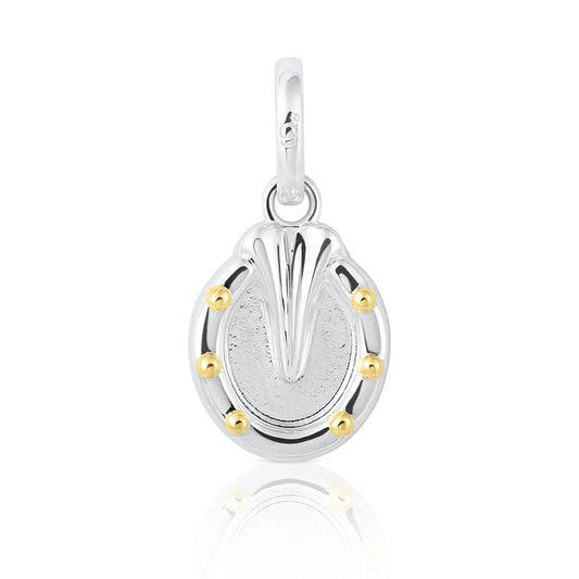 A sterling silver horseshoe charm pendant with a textured center, polished top, and five small gold bezel-set accents around the perimeter, shown on a white background with a soft reflection.